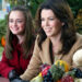 Rory and Lorelai Gilmore sit at a picnic bench smiling.