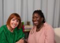 two women smiling in a podcast studio