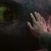 How To Train Your Dragon's Mason Thames places his hand on dragon Toothless' pebbled black face. .