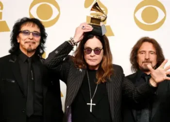 Reuters Bandmates Tony Iommi, Ozzy Osbourne and Geezer Butler pose in front of yellow and white Grammy logos while holding a grammy award for Best Metal Performance at the 2014 Grammy awards