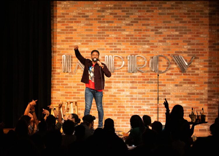Unaka onstage at the Improv comedy club.