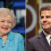 Betty White smiles wearing blue coat, David Boreanaz sports black suit.