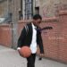 A young boy walks in a school uniform with a basketball on the cover art for Blood Orange's "Essex Honey."