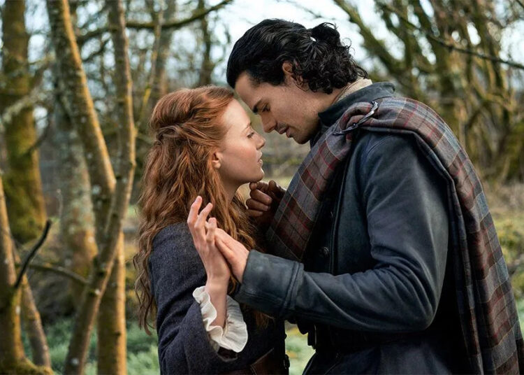 a romantic scene between two individuals in a forested area