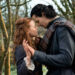 a romantic scene between two individuals in a forested area