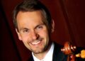 white man wearing suit and red tie holds cello, Christopher Hutton
