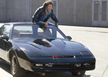 Michael Knight (David Hasselhoff) stands up through the sunroof of KITT in Knight Rider.