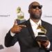 Man in suit and sunglasses holding up a Grammy award statue