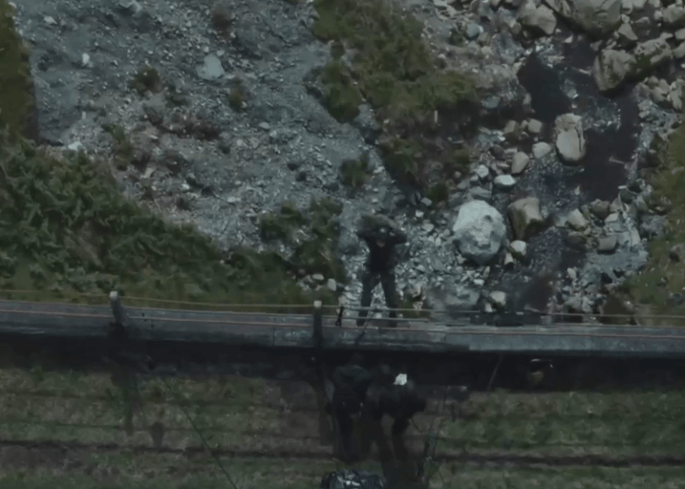 Aerial view of people working near a rocky stream.