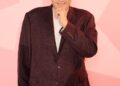 Mark Labbett from Celebs Go Dating, smiling and touching his chin.