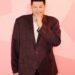 Mark Labbett from Celebs Go Dating, smiling and touching his chin.