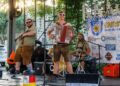 A man playing the accordion and another joining him with the trumpet at a German themed venue.