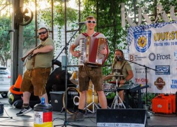A man playing the accordion and another joining him with the trumpet at a German themed venue.