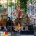 A man playing the accordion and another joining him with the trumpet at a German themed venue.