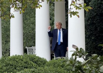 President Trump pumps his fist as he tests out the new outdoor speaker system in the Rose Garden