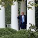 President Trump pumps his fist as he tests out the new outdoor speaker system in the Rose Garden