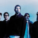 Deftones looking serious against a light blue backdrop