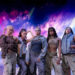 Five individuals pose confidently in futuristic, casual outfits, with an outer space backdrop featuring stars and planets