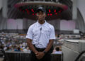 Tyrone Huntley stands with a slight smile with the Hollywood Bowl stage behind him.