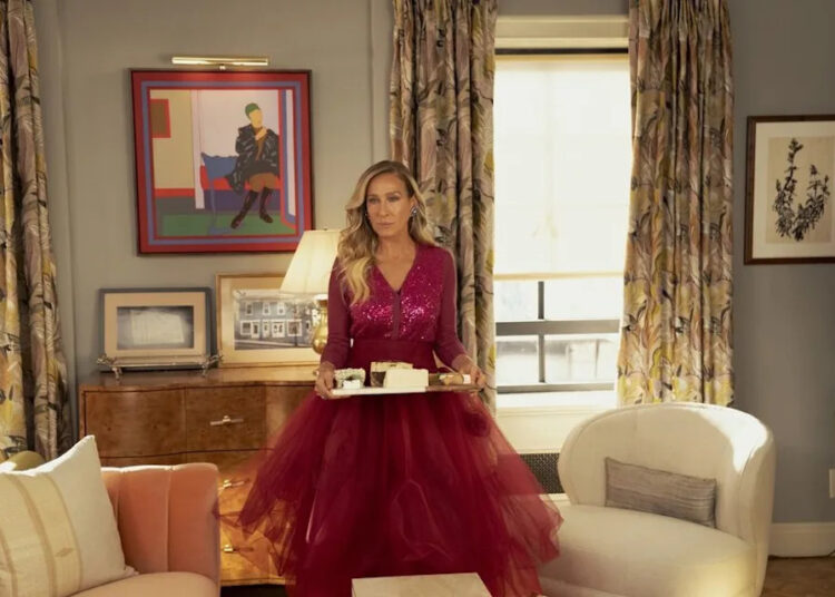 Sarah Jessica Parker as Carrie Bradshaw standing and holding a tray.