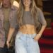 Jennifer Lopez wears a cropped gray T-shirt, light-wash wide-leg jeans, sunglasses and a New York Yankees cap while walking outside with a bodyguard.