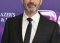 Jimmy Kimmel wearing a dark suit and tie at a red carpet event