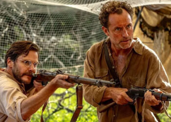 Daniel Bruhl and Jude Law pointing guns in Eden.