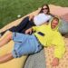 two people lounging on a picnic blanket