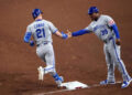 Kansas City Royals outfielder Mark Canha (21) slaps hands with Kansas City Royals first base coach Damon Hollins (39) after hitting a solo home run against the Arizona Diamondbacks during the fifth inning at Chase Field on July 4, 2025.