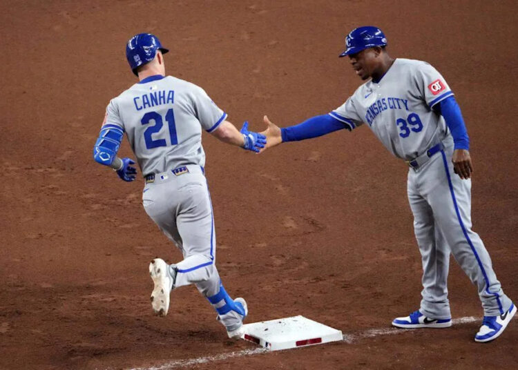 Kansas City Royals outfielder Mark Canha (21) slaps hands with Kansas City Royals first base coach Damon Hollins (39) after hitting a solo home run against the Arizona Diamondbacks during the fifth inning at Chase Field on July 4, 2025.