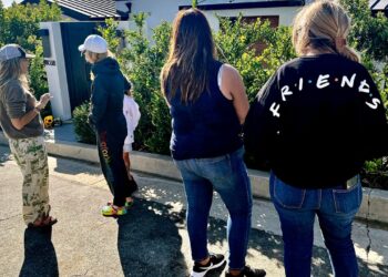 Mourners stand outside the home of actor Matthew Perry, Sunday, Oct. 29, 2023, in the Pacific Palisades area of Los Angeles. Perry, who starred as Chandler Bing in the hit series "Friends," has died. He was 54. (AP Photo/Eugene Garcia)