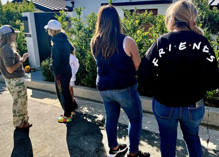 Mourners stand outside the home of actor Matthew Perry, Sunday, Oct. 29, 2023, in the Pacific Palisades area of Los Angeles. Perry, who starred as Chandler Bing in the hit series "Friends," has died. He was 54. (AP Photo/Eugene Garcia)