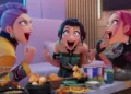 Netflix The three main characters in the Netflix animated movie Kpop Demon Hunters sit at a table full of food and celebrate.