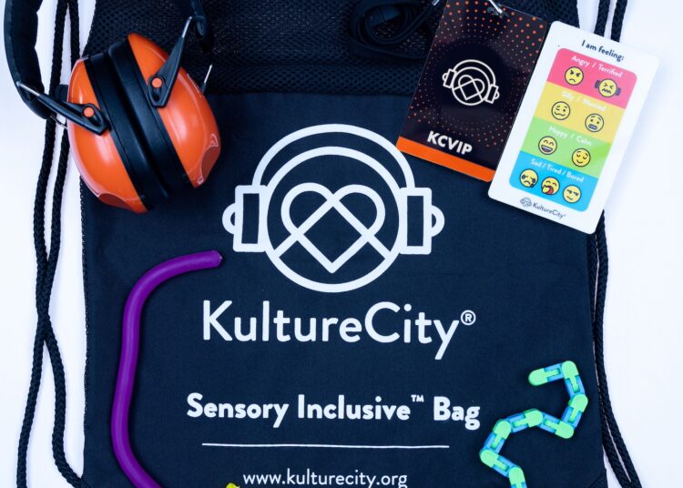 The contents of the KultureCity sensory bags, including fidget toys, strobe reduction glasses, a communication cue-card depicting emotions, and noise-reduction headphones — sensory inclusive events