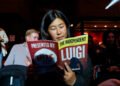 Bryn Levitan reads the show program before watching “Luigi: The Musical,” written by several Bay Area comedians, about three high-profile inmates being held in a Brooklyn prison. - (Camille Cohen/For The Washington Post)