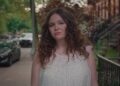 megan stalter as jessica walking down a brooklyn street in too much