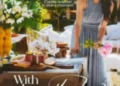 Meghan Markle in a light blue dress stands next to a table decorated with flowers and food in a garden, with the text