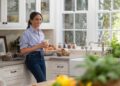 Meghan Markle in a kitchen, holding a mug.