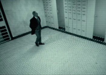 A man in a suit walking through a vault, as seen through a security camera in Stolen: Heist of the Century.