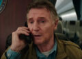 Liam Neeson sits on the phone in a plane in Cold Storage.