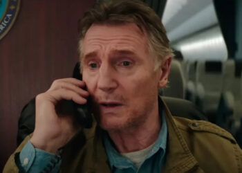 Liam Neeson sits on the phone in a plane in Cold Storage.