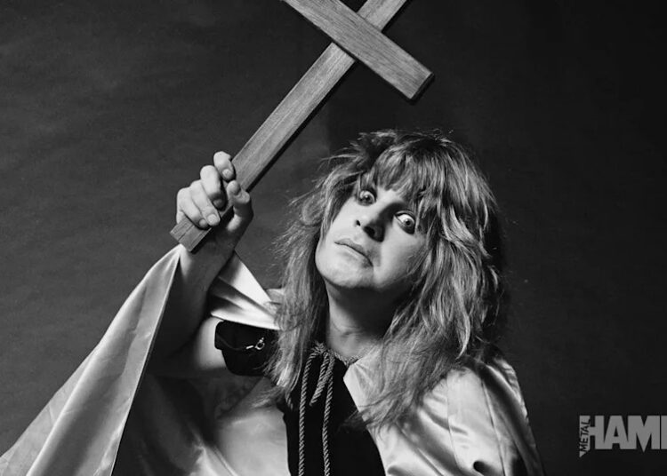 A black-and-white photo of Ozzy Osbourne holding a large wooden cross.