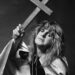 A black-and-white photo of Ozzy Osbourne holding a large wooden cross.