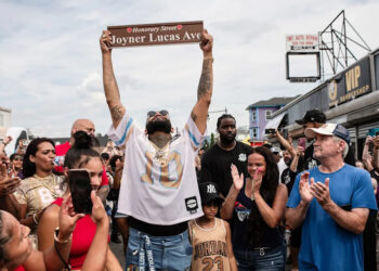 Worcester music artist Joyner Lucas raises his sign after a section of Dewey Street was named in his honor Sunday Aug. 17.