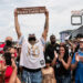 Worcester music artist Joyner Lucas raises his sign after a section of Dewey Street was named in his honor Sunday Aug. 17.