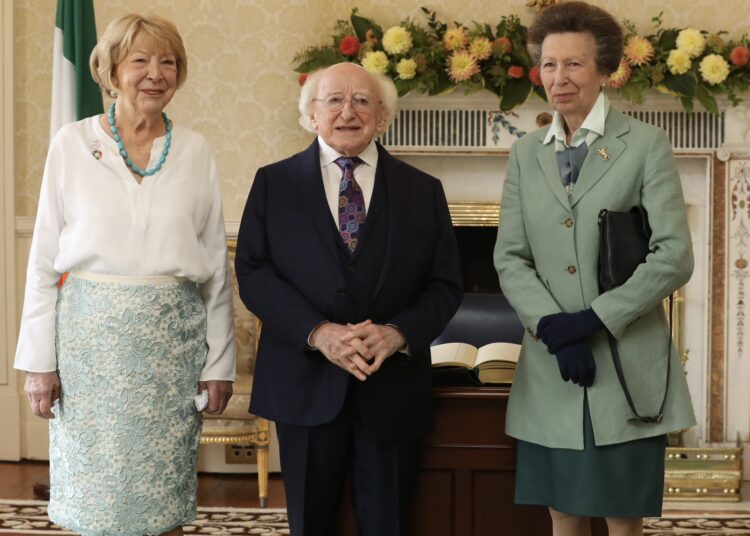 Princess Anne wearing a green blazer standing with the President of Ireland, Michael D. Higgins, and his wife Sabina Higgins
