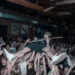 Zach Smith of The Espionage Act plays guitar while crowd surfing during a concert.