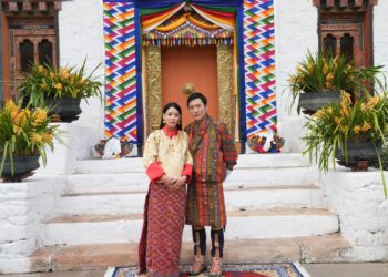 Ugen Choden Namgyel and Prince Jigyel standing outside a building