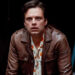 Sebastian Stan stands leaning over a table with a look of upset in A Different Man.