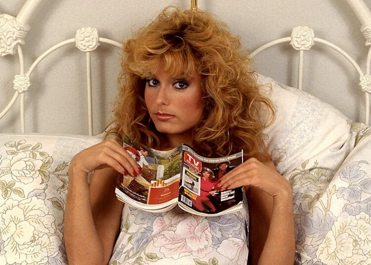 Tracey Bregman with a "TV Guide" in bed